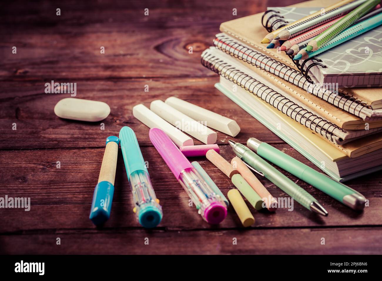 Schulbedarf mit Übungsbuch und Notizblöcken auf Holzhintergrund. Wieder-in-die-Schule-Konzept Stockfoto