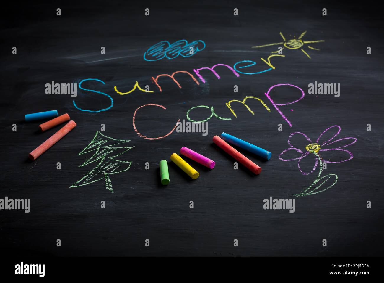 Text Sommercamp auf schwarzer Tafel geschrieben, mit Kreidestäben in verschiedenen Farben Stockfoto