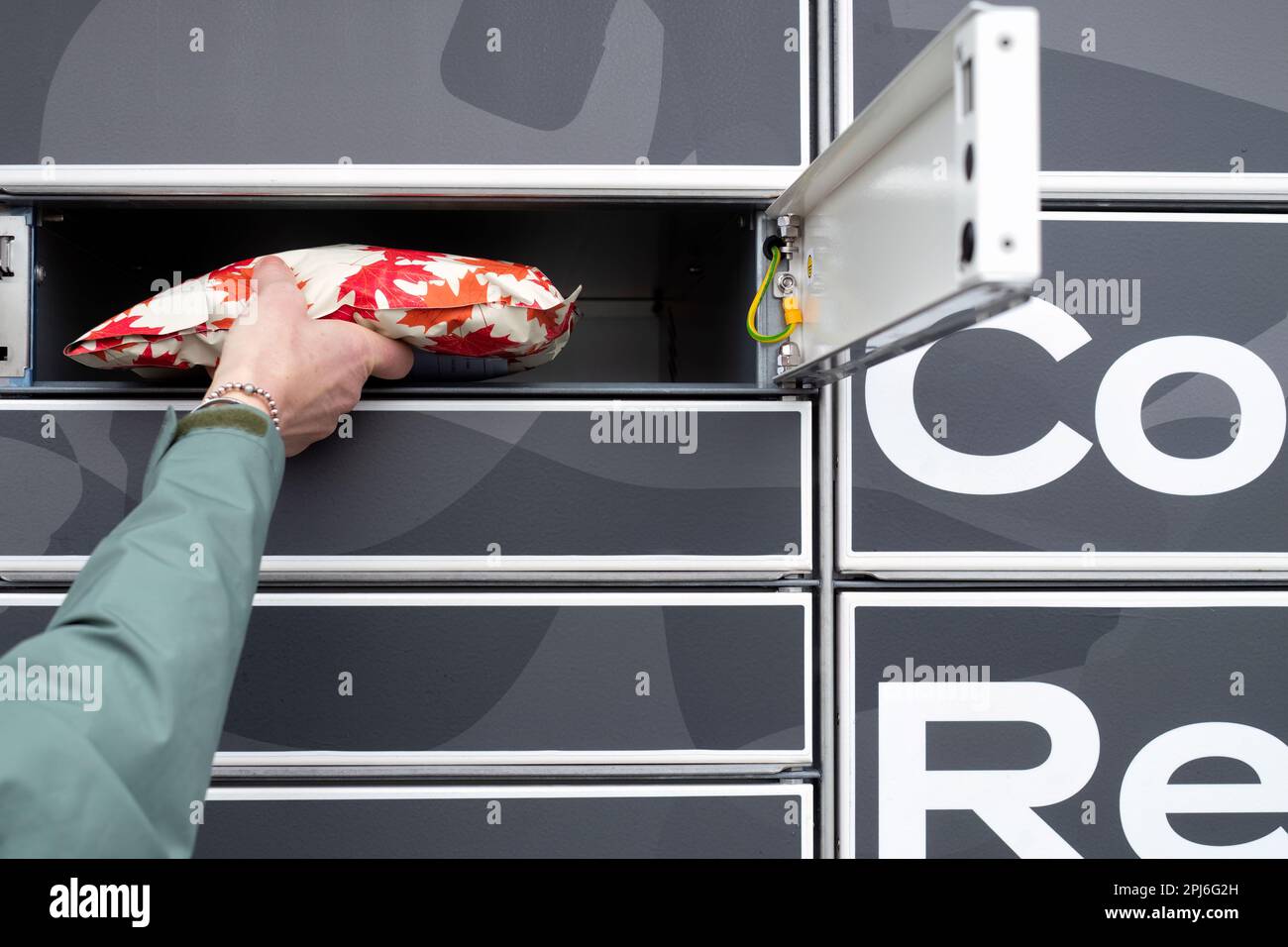 Ein Kunde liefert oder holt ein Paket nach Abschluss eines Verkaufs an ein Collectplus-Schließfach ab. Ein Abhol- und Abholservice für Paketzustellungen in Großbritannien Stockfoto
