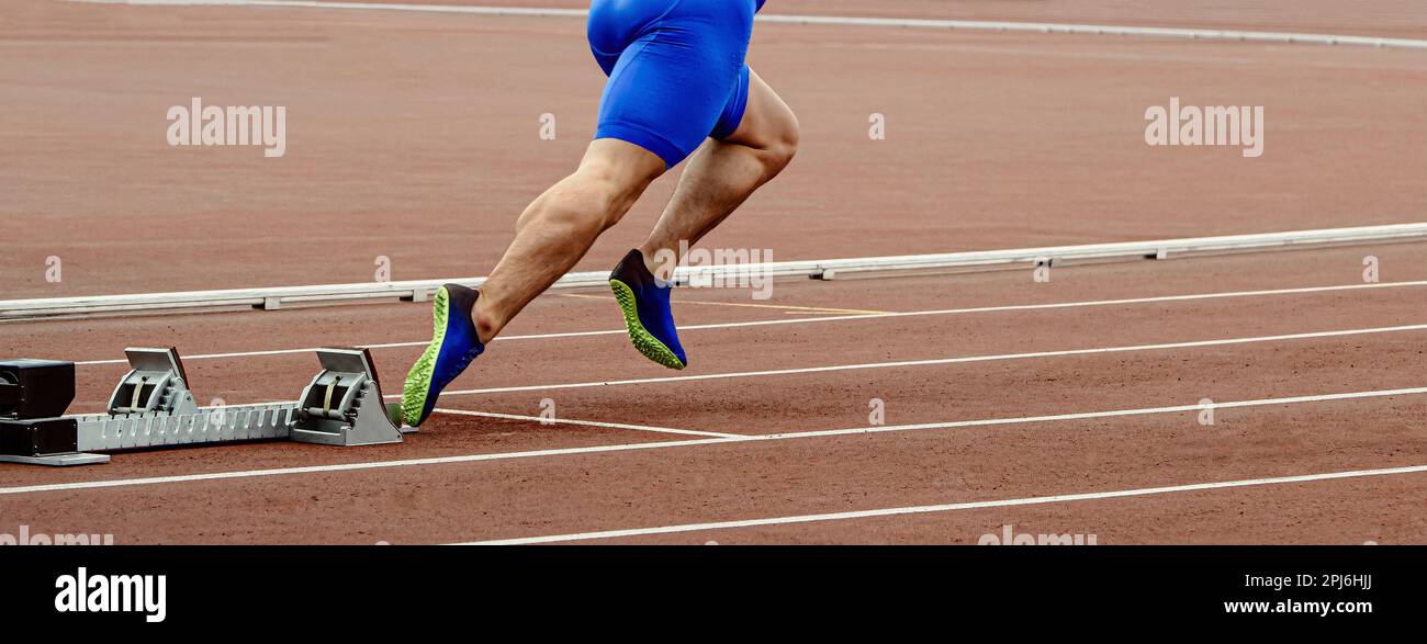 Beine männlicher Sprinter Läufer beginnt mit dem Laufen in Startblöcken, Sportwettkämpfen und Sommersportspielen Stockfoto