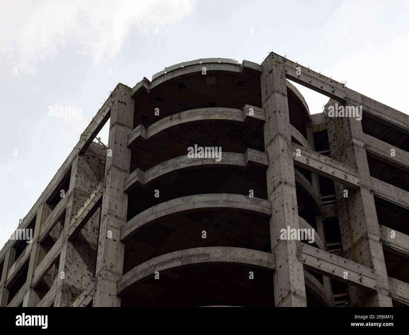 Verlassene Ruine eines Bürokomplexes. Stahlbetonkonstruktion ohne Fenster und Fassadenelemente. Erstellung aufgrund eines nicht erfolgreichen Projekts. Stockfoto