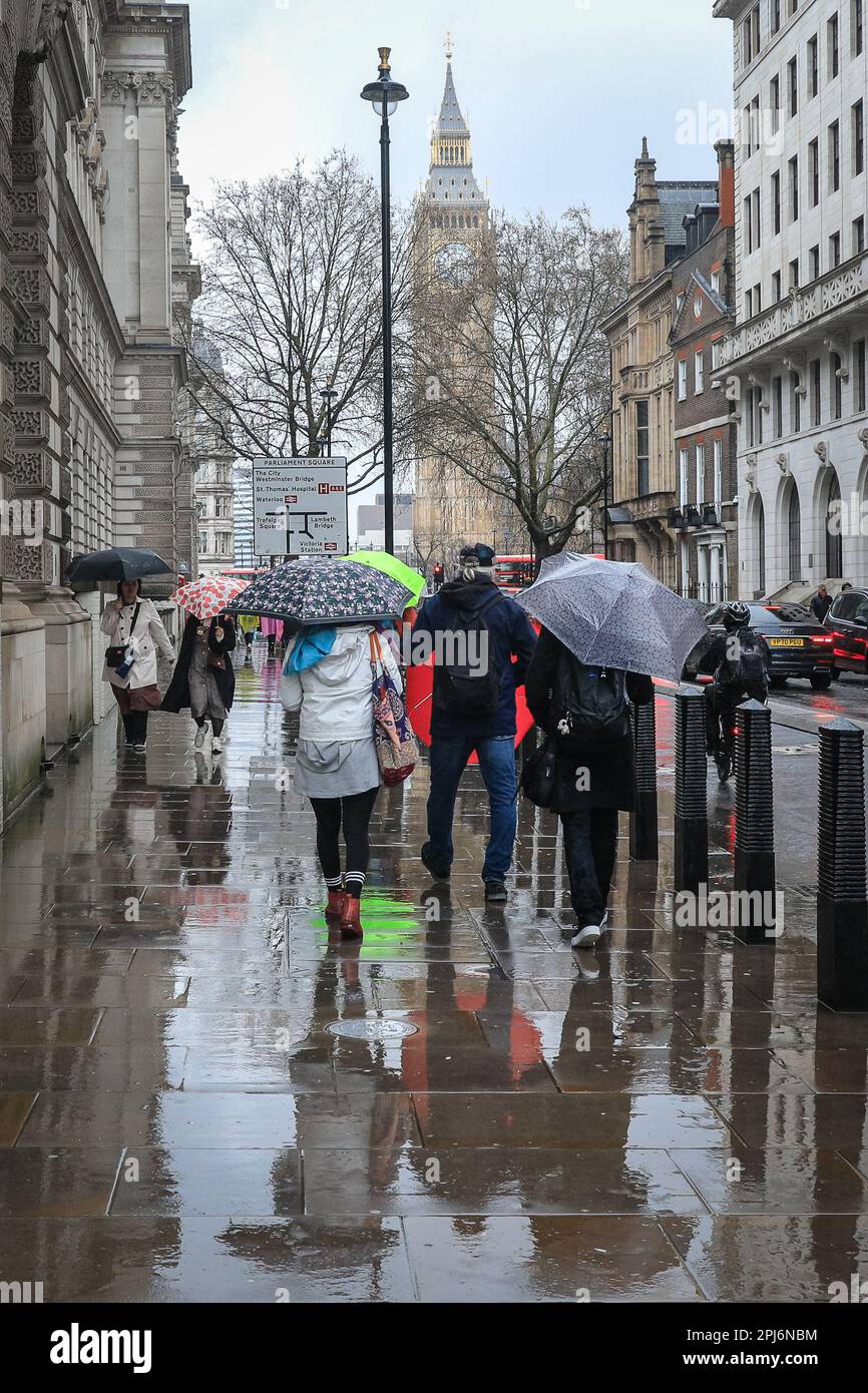 London, Großbritannien. 31. März 2023. Londoner und Touristen bekommen ihre Schirme raus, während sie einen Spaziergang durch die Westminster Sehenswürdigkeiten im Zentrum von London machen, an einem Tag, der meist grau und sehr regnerisch in der Hauptstadt war. Kredit: Imageplotter/Alamy Live News Stockfoto