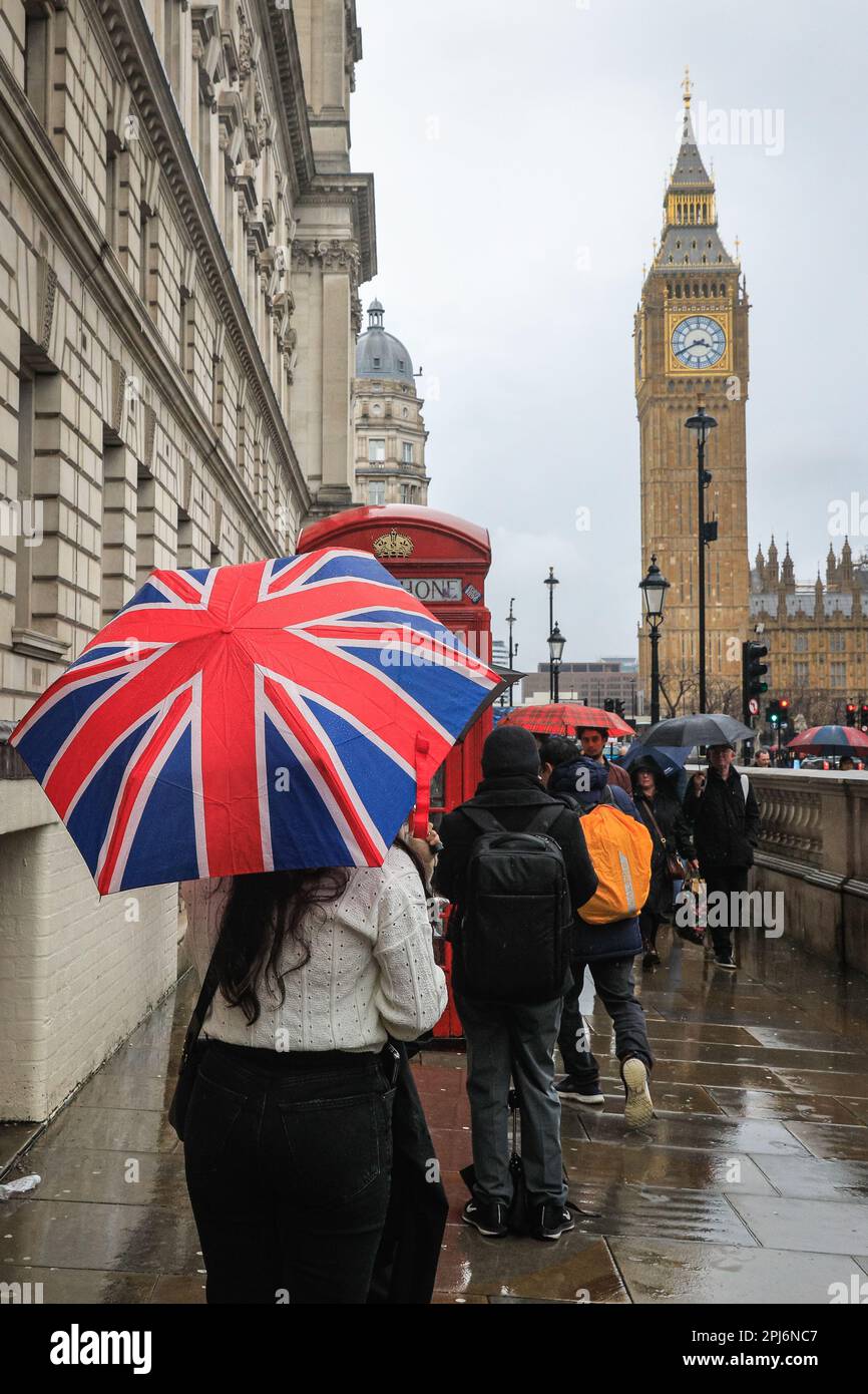 London, Großbritannien. 31. März 2023. Londoner und Touristen bekommen ihre Schirme raus, während sie einen Spaziergang durch die Westminster Sehenswürdigkeiten im Zentrum von London machen, an einem Tag, der meist grau und sehr regnerisch in der Hauptstadt war. Kredit: Imageplotter/Alamy Live News Stockfoto