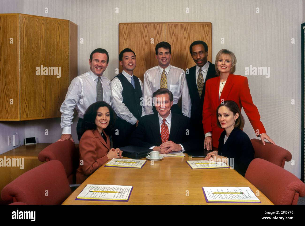 1996 HISTORISCHE, MULTIETHNISCHE BÜROANGESTELLTE TREFFEN SICH AM TISCH Stockfoto