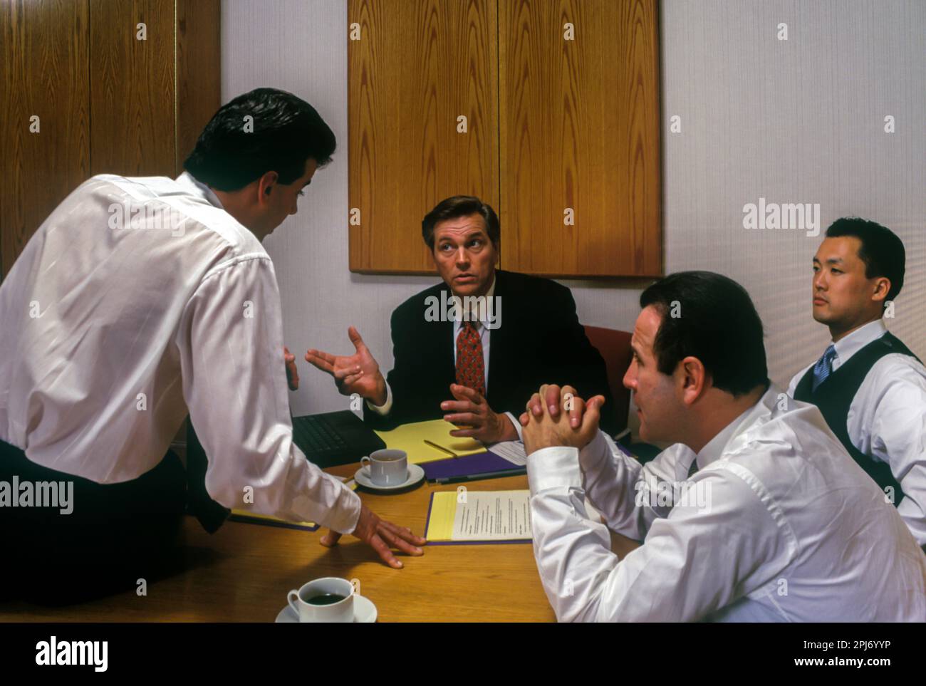 1996 HISTORISCHE BÜROANGESTELLTE TREFFEN SICH AM TISCH Stockfoto