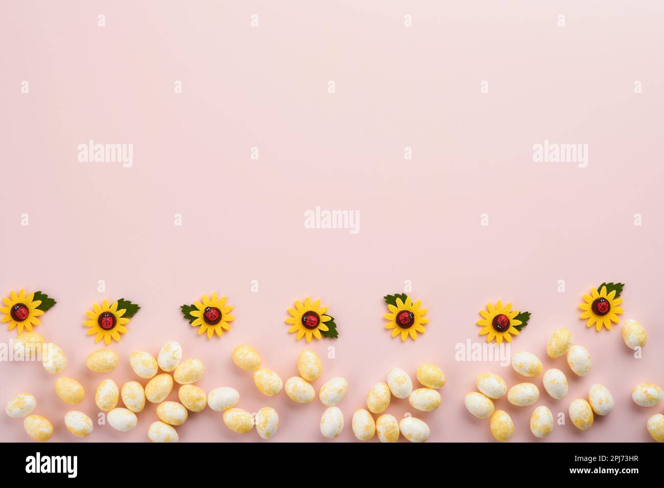 Frohe Ostern. Ostereier und weiße Kaninchen, isoliert auf trendigen pastellrosa Hintergrund mit weißen und gelben Rosen. Frühling Frohe Osterfeier Stockfoto