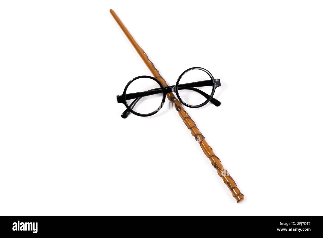 Runde schwarze Brille und brauner Zauberstab isoliert auf weißem Hintergrund. Stockfoto