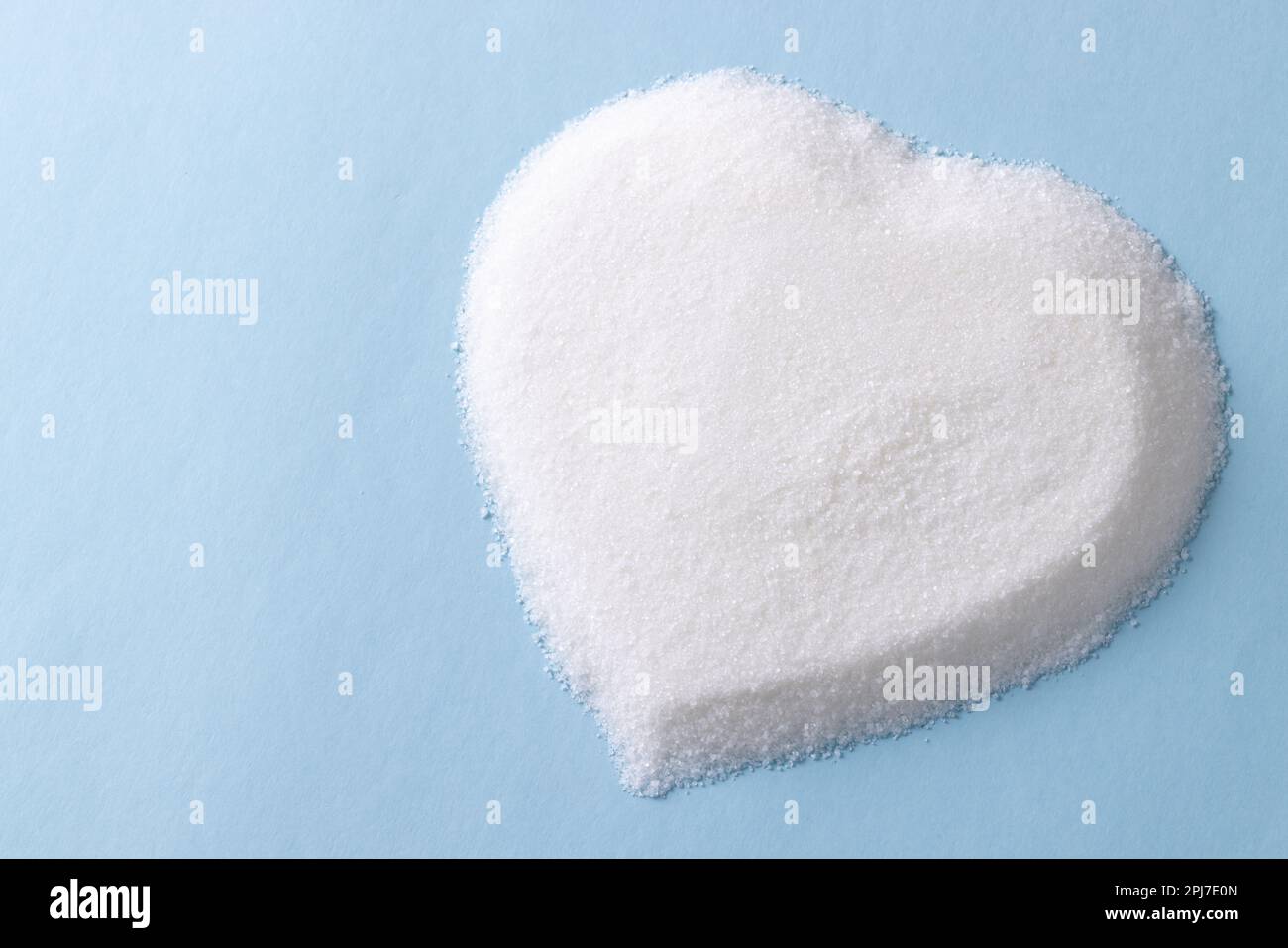 Zucker in Herzform auf blauem Hintergrund Stockfoto