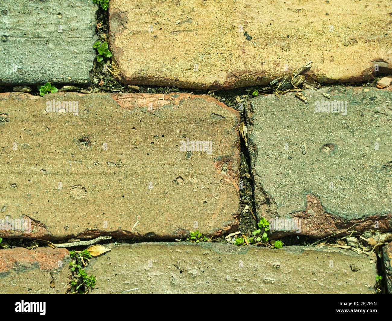 Nahaufnahme einer roten Ziegelstraße in einem gestaffelten Muster. Dies ist der perfekte Hintergrund, um Text darüber hinzuzufügen. Viel Platz zum Kopieren verfügbar. Stockfoto