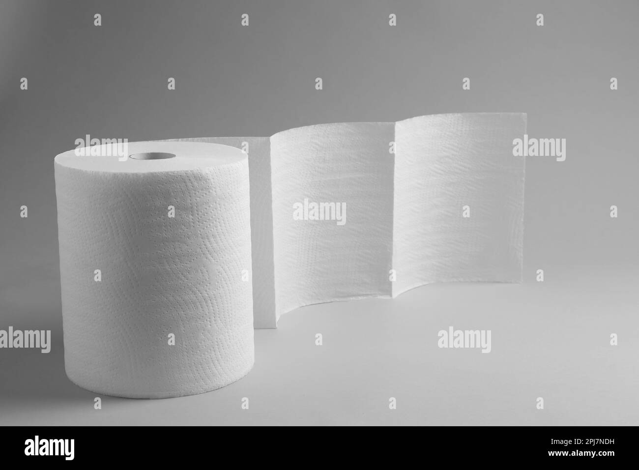 Rolle weißer Papiertücher auf grauem Hintergrund. Platz für Text Stockfoto