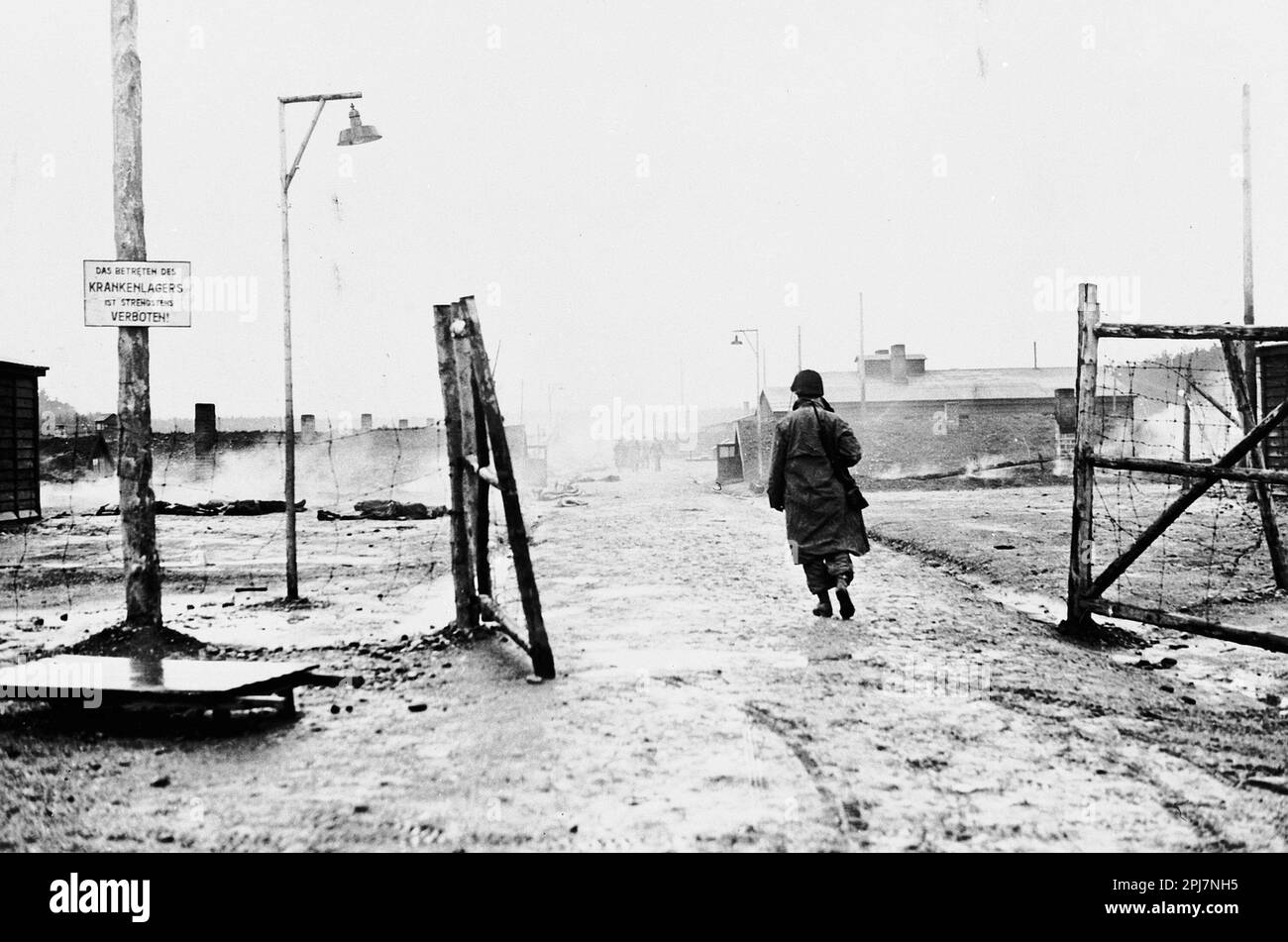 Ein amerikanischer Soldat in den Toren von Kaufering IV, Teil des KZ Dachau nach seiner Befreiung Stockfoto