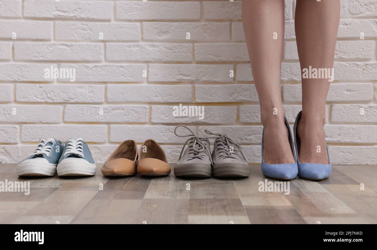 Verschiedene bequeme Schuhe in der Nähe von Frauen in Schuhen mit hohen  Absätzen in Innenräumen, Nahaufnahme Stockfotografie - Alamy