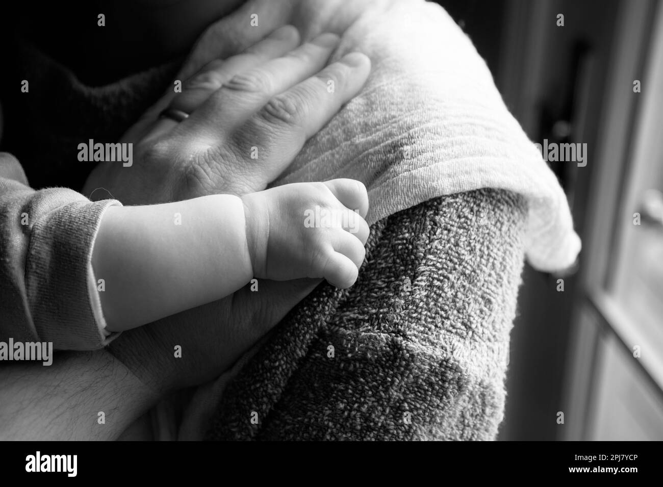 Neues Baby hält den Daumen der neuen mutter nach dem Füttern Stockfoto