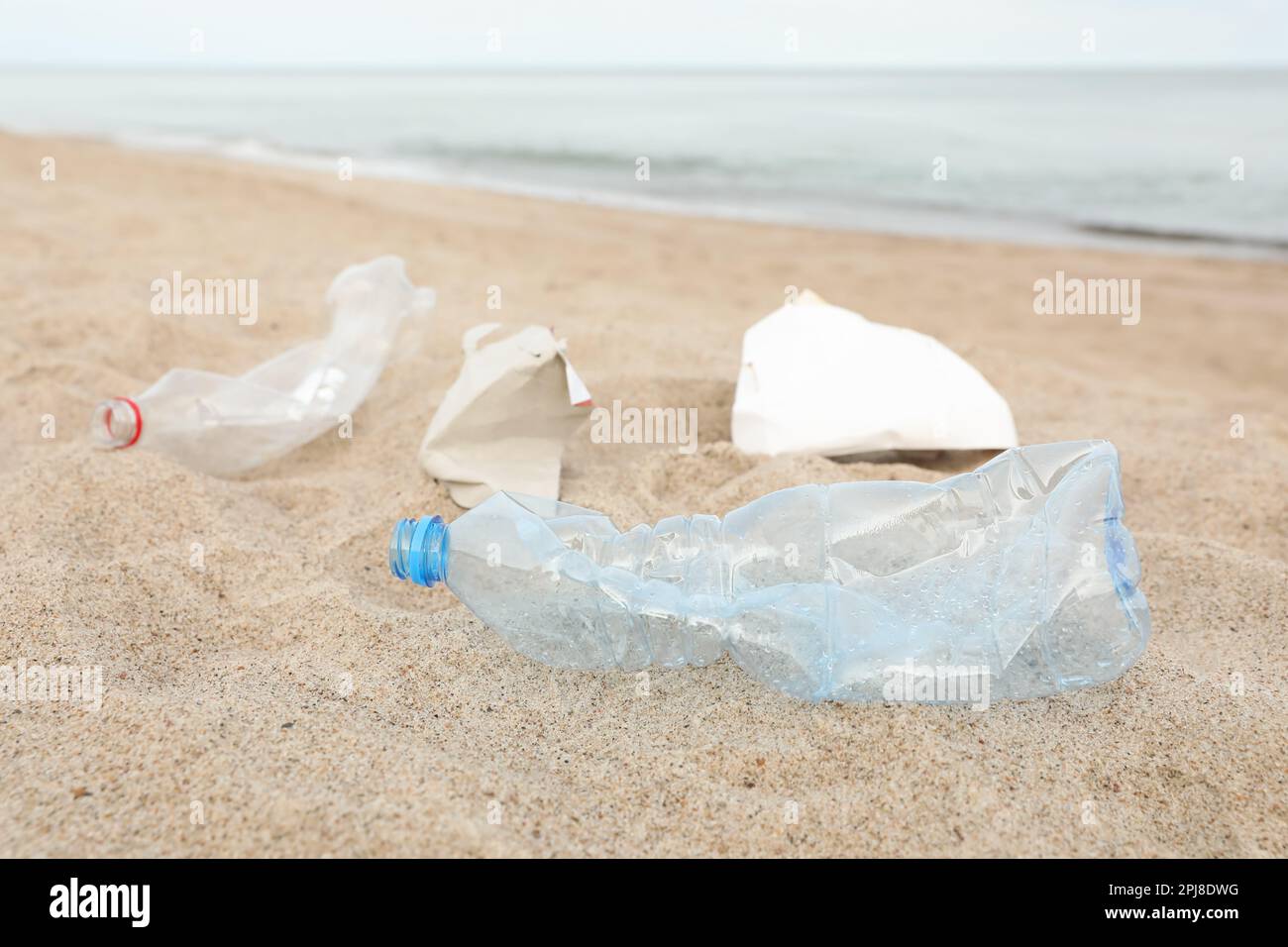 Müll verstreut am Strand in der Nähe des Meeres, dicht gemacht. Recycling-Problem Stockfoto