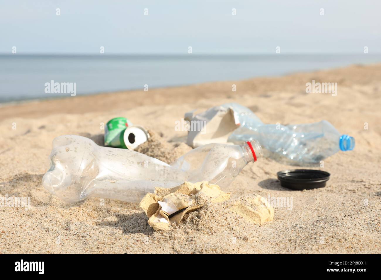 Müll verstreut am Strand in der Nähe des Meeres, dicht gemacht. Recycling-Problem Stockfoto