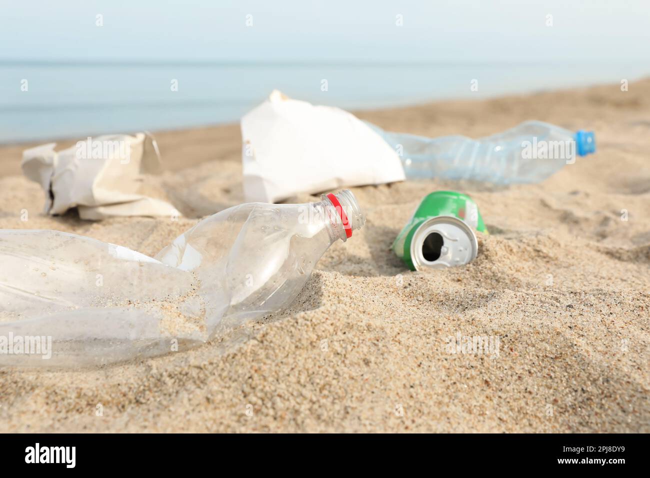 Müll verstreut am Strand in der Nähe des Meeres, dicht gemacht. Recycling-Problem Stockfoto