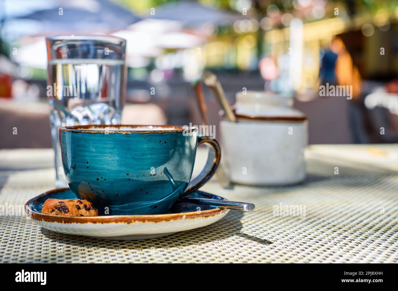 eine tasse Espresso, ein Glas Wasser und Kekse auf dem Tisch, Nahaufnahme, selektiver Fokus Stockfoto