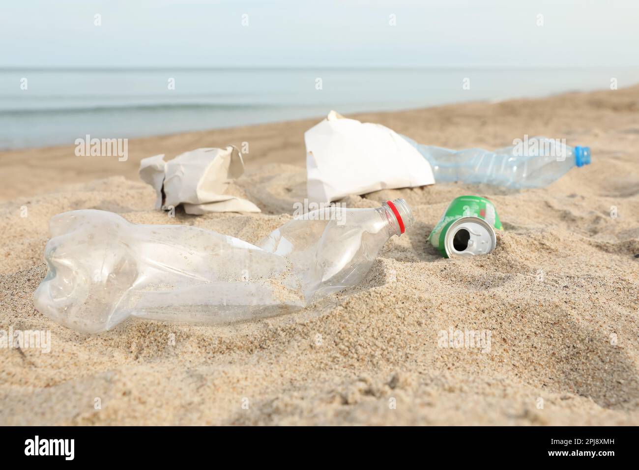 Müll verstreut am Strand in der Nähe des Meeres, dicht gemacht. Recycling-Problem Stockfoto