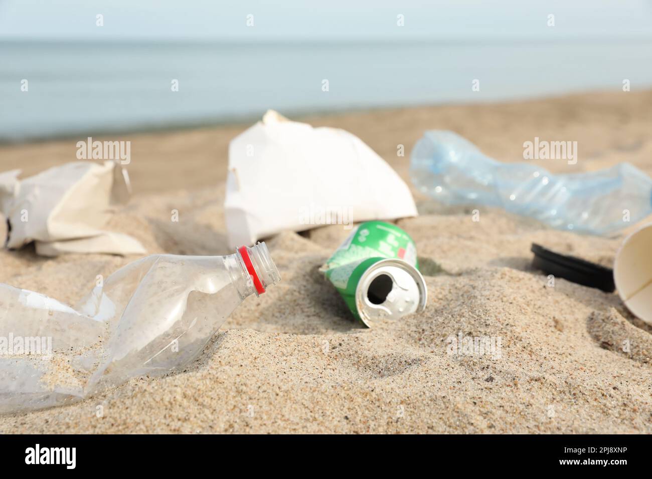 Müll verstreut am Strand in der Nähe des Meeres, dicht gemacht. Recycling-Problem Stockfoto