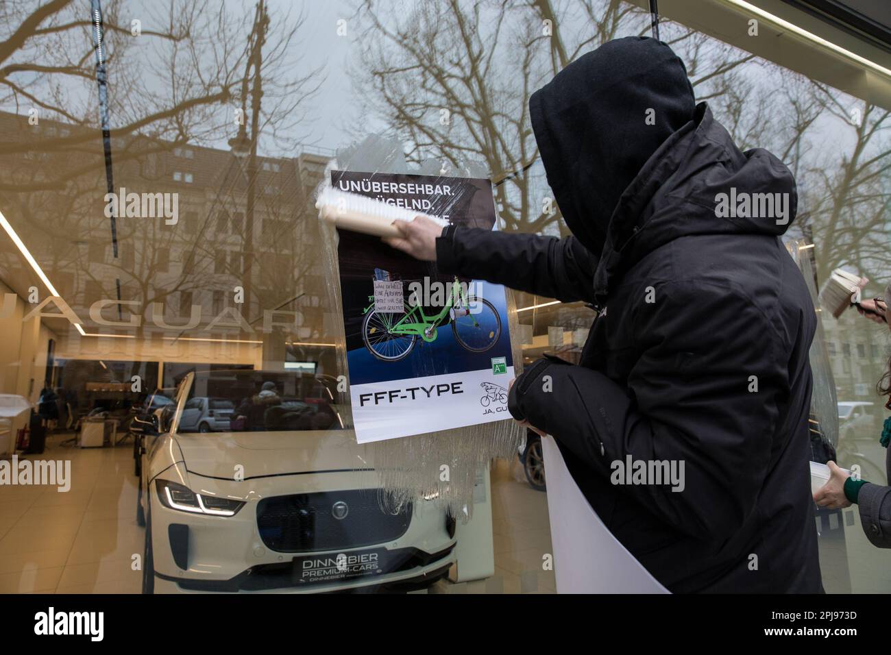 1. April 2023, Berlin, Deutschland: Am 1. April 2023 versammelten sich am Kurfürstendamm in Berlin etwa 30 Aktivisten des Aussterbens Rebellion, um einen Luxussportwagenhändler spielerisch zu verarschen. Mit Fahrrädern, um den Eingang zu blockieren, schlugen die Aktivisten scherzhaft vor, dass der Hersteller von Luxusfahrzeugen eine neue Reihe emissionsfreier Fahrzeuge in Form von Fahrrädern einführe. Außerdem wurde ein Banner mit dem Text „die neue Jaguar Produktlinie“ angezeigt. Pedalkraft. Emissionsfrei.“ Und verputzte Plakate am Schaufenster, auf denen die neuen, klimafreundlichen „Jaguar“-Produkte beworben werden. Nach Hig Stockfoto