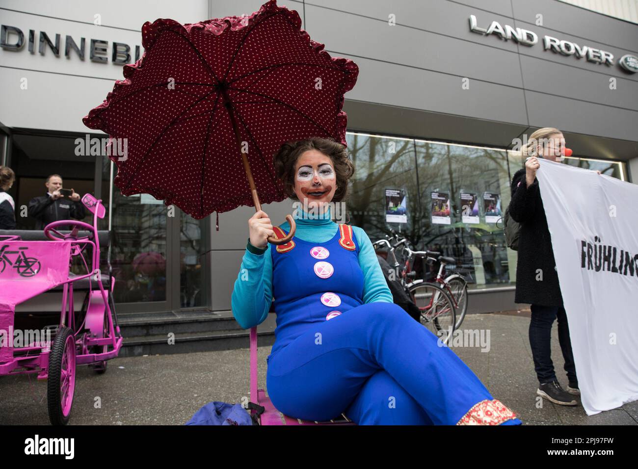 1. April 2023, Berlin, Deutschland: Am 1. April 2023 versammelten sich am Kurfürstendamm in Berlin etwa 30 Aktivisten des Aussterbens Rebellion, um einen Luxussportwagenhändler spielerisch zu verarschen. Mit Fahrrädern, um den Eingang zu blockieren, schlugen die Aktivisten scherzhaft vor, dass der Hersteller von Luxusfahrzeugen eine neue Reihe emissionsfreier Fahrzeuge in Form von Fahrrädern einführe. Außerdem wurde ein Banner mit dem Text „die neue Jaguar Produktlinie“ angezeigt. Pedalkraft. Emissionsfrei.“ Und verputzte Plakate am Schaufenster, auf denen die neuen, klimafreundlichen „Jaguar“-Produkte beworben werden. Nach Hig Stockfoto