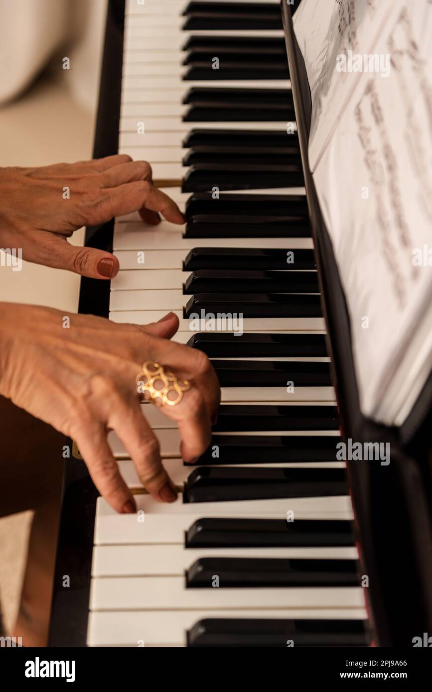 Talentierte Frauenhände, die nachts zu Hause Klavier spielen. Musik und Perfektion. Stockfoto