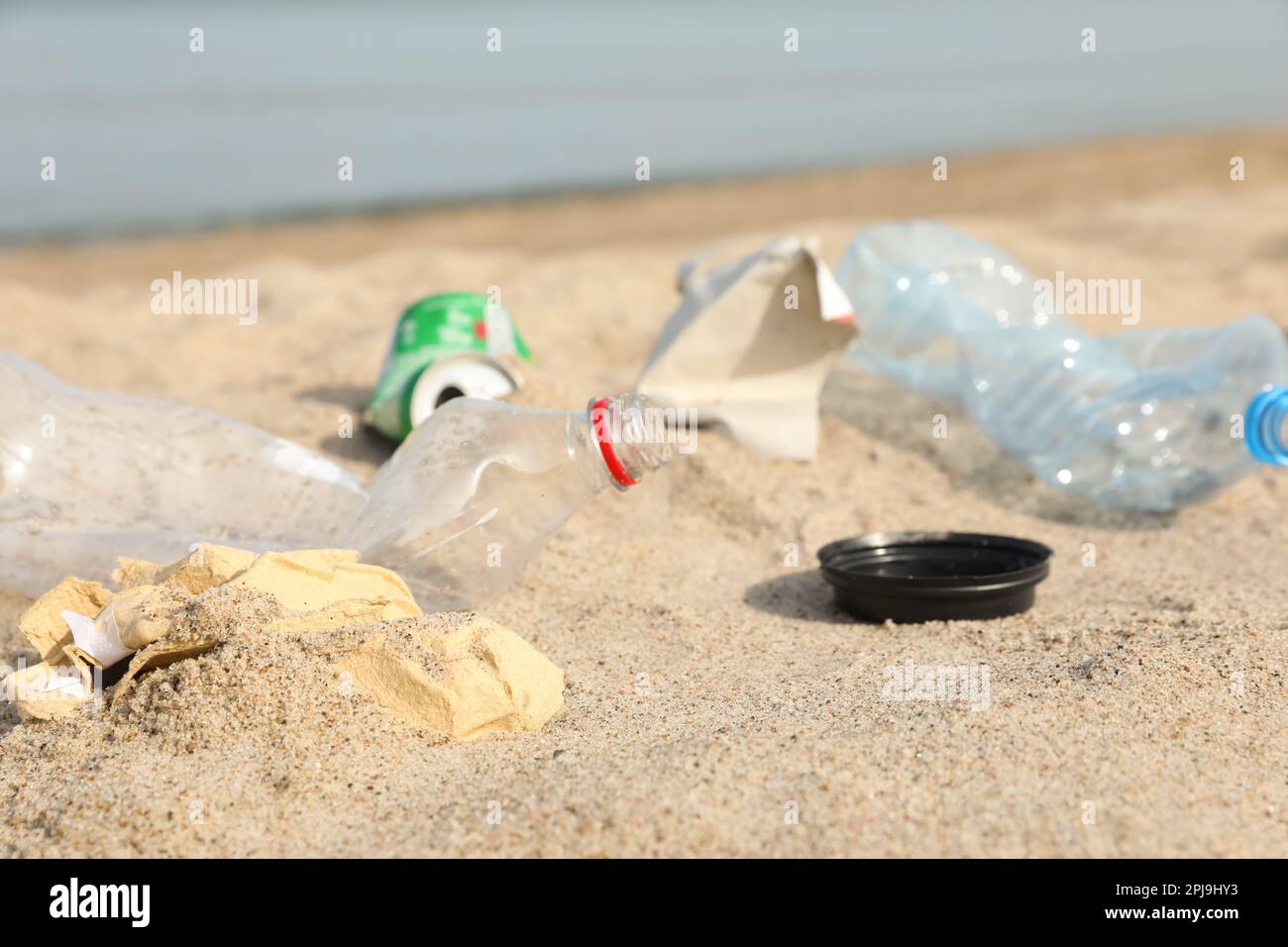 Müll verstreut am Strand in der Nähe des Meeres, dicht gemacht. Recycling-Problem Stockfoto