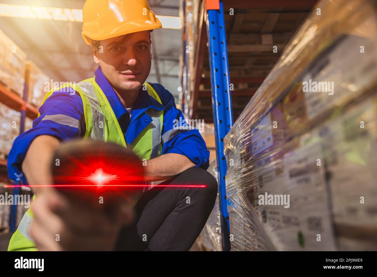 Lagermitarbeiter mit rotem Laser-Barcode-Scanner zum Scannen von Etiketten und Geräten für die Warenverwaltung Stockfoto