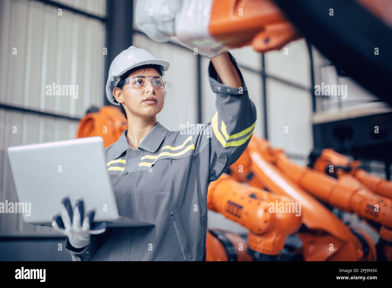 Ingenieurin, die im Maschinenwerk arbeitet. indische Ingenieurinnen prüfen Roboterarm im Montagewerk Stockfoto