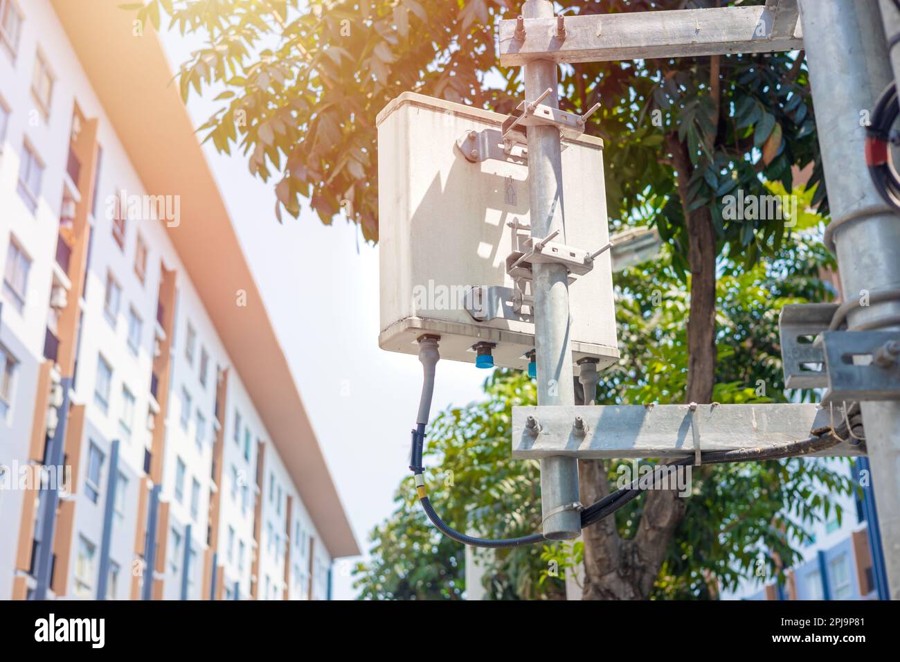 4G- oder 5G-Mobilfunkkommunikation in der Stadt. Funkturm der Basisstation für direktionale Rasterzellen. Wide Area Telecommunication Tower mit Scheibe Stockfoto