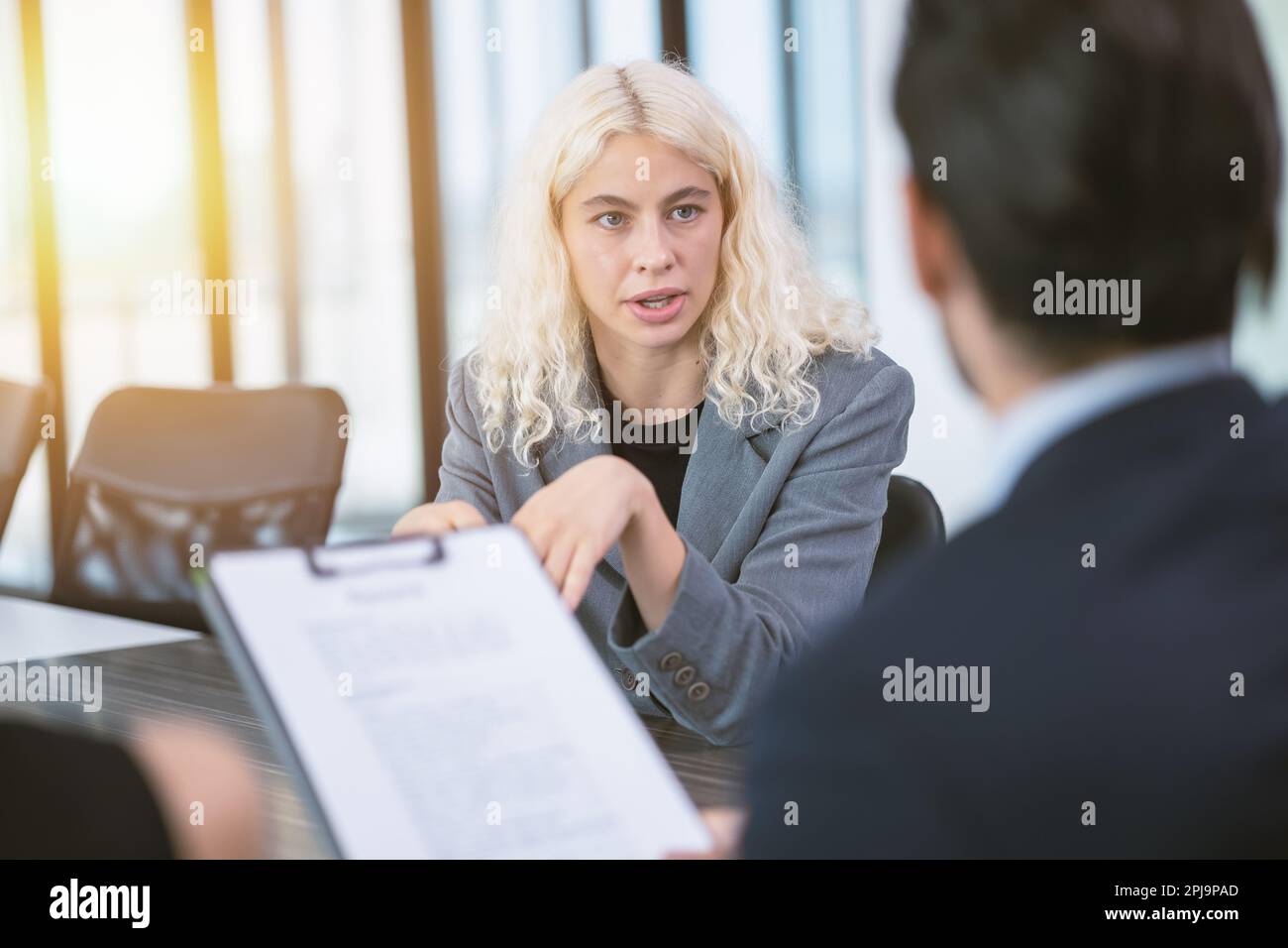 Junge Geschäftsfrau mit fokussierten Augen sprechen Sie mit Ihrem Chef aufmerksam im Besprechungsraum für ein Vorstellungsgespräch Stockfoto