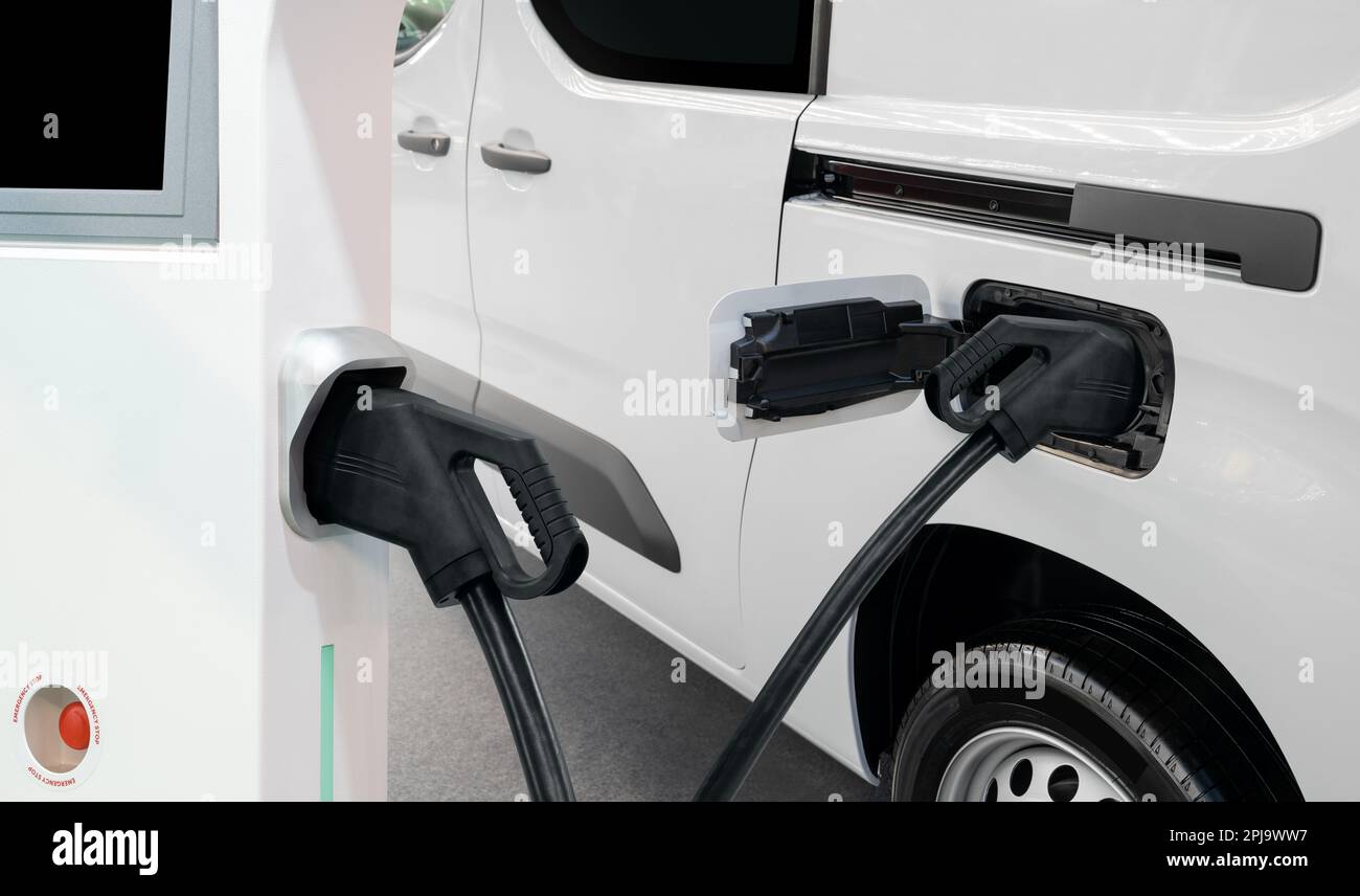 Elektrischer Lieferwagen mit Ladestation für Elektrofahrzeuge. Hochwertiges Foto Stockfoto