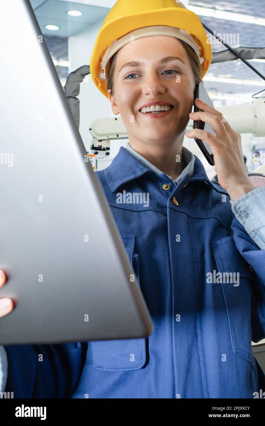 Ingenieurin mit digitalem Tablet und Smartphone in einer intelligenten Fabrik. Schließen. Hochwertiges Foto Stockfoto