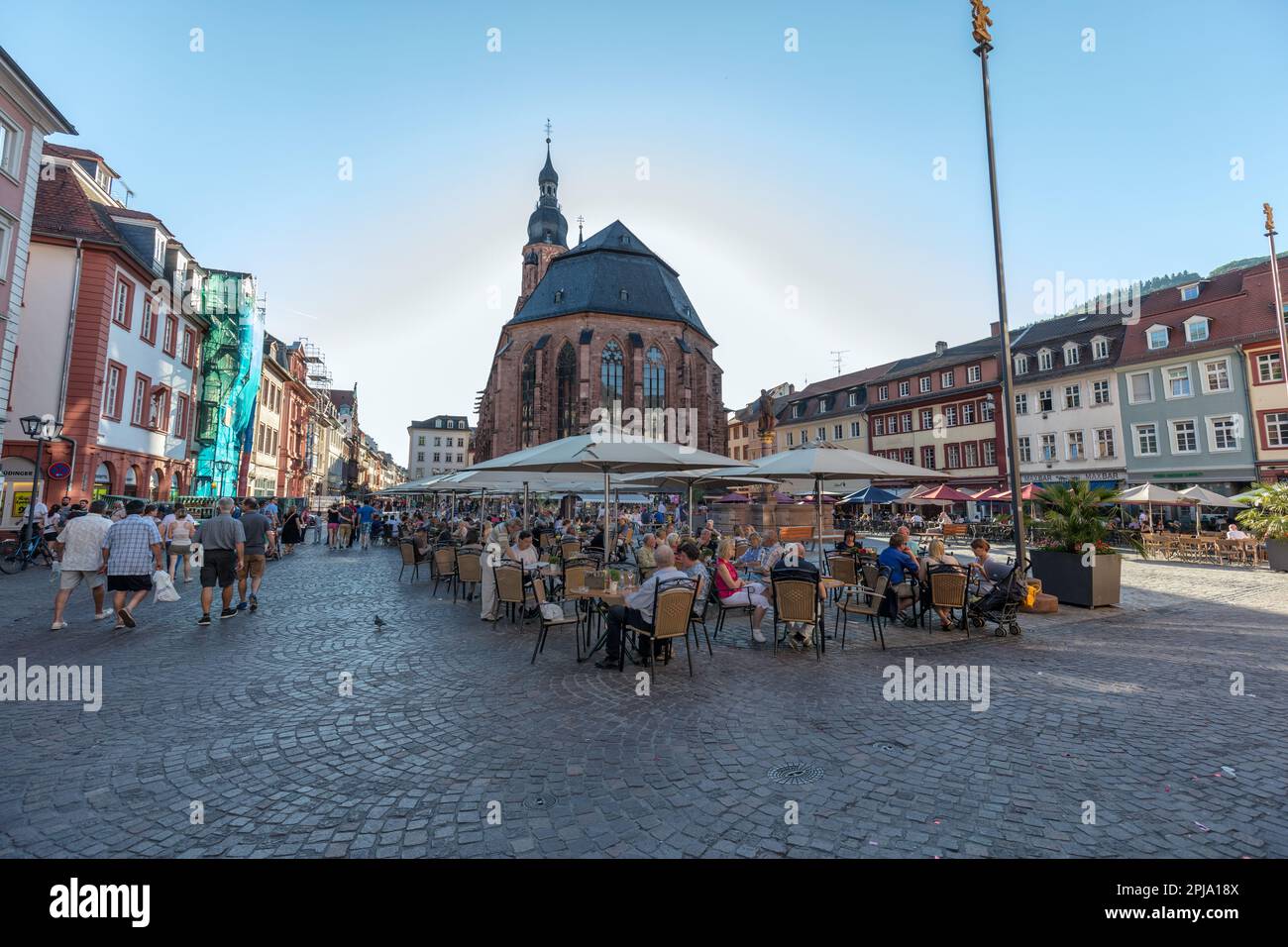 Menschen in Cafés und Bars am Marktplatz - Marktplatz in der historischen Altstadt neben der Heiligen Geisterkirche oder der Heiliggeistkirche. Heidelberg. Stockfoto