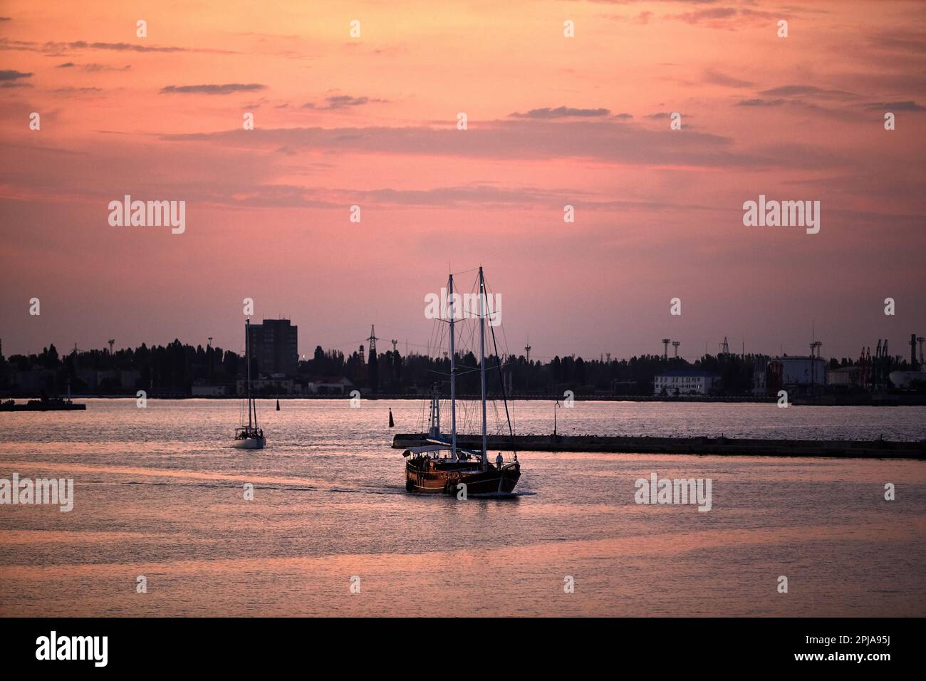 Eine hölzerne Yacht im Hafen bei Sonnenuntergang Stockfoto
