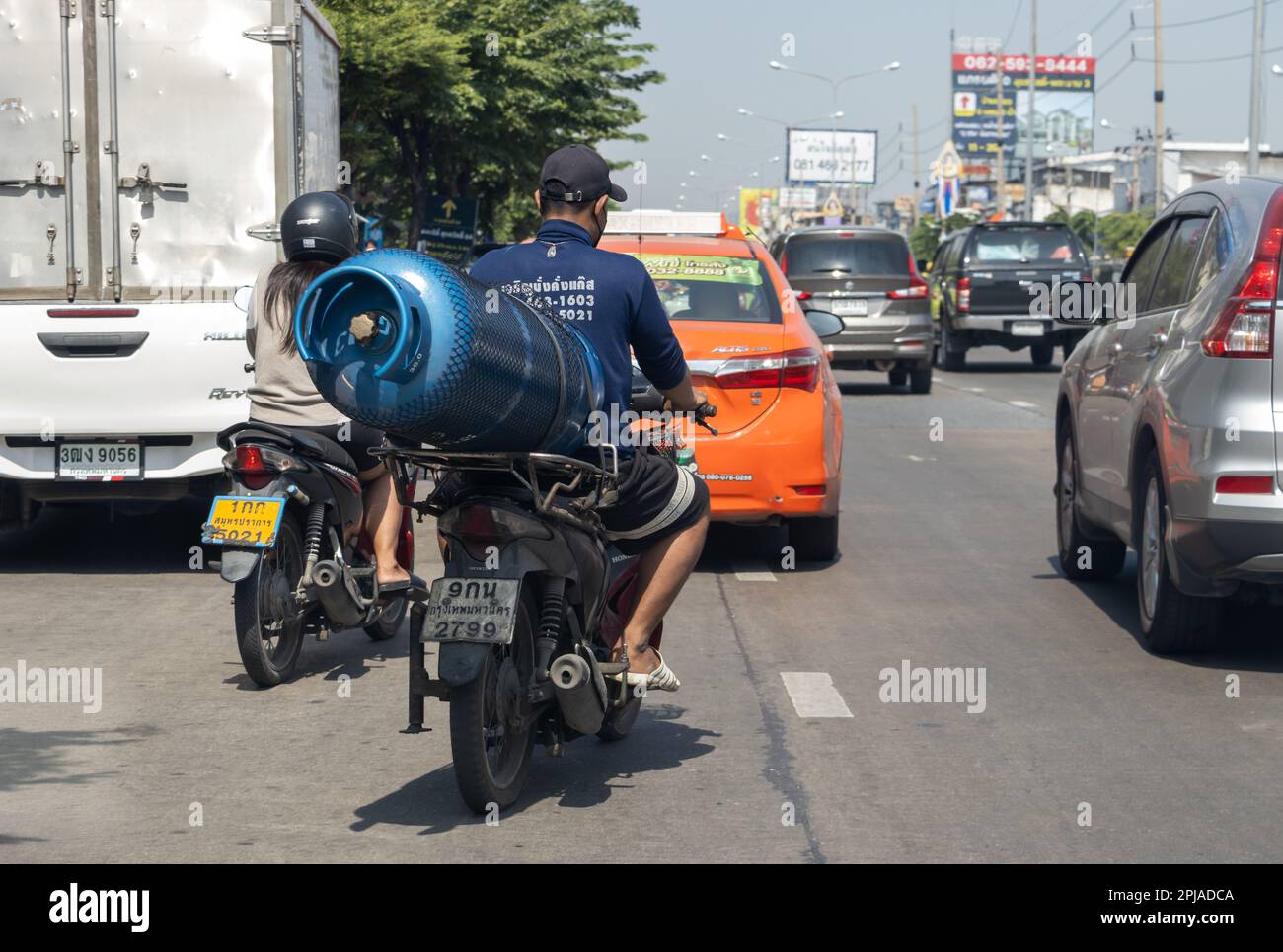 SAMUT PRAKAN, THAILAND, JANUAR 21 2023, Ein Mann transportiert eine große Gasflasche auf einem Motorrad Stockfoto