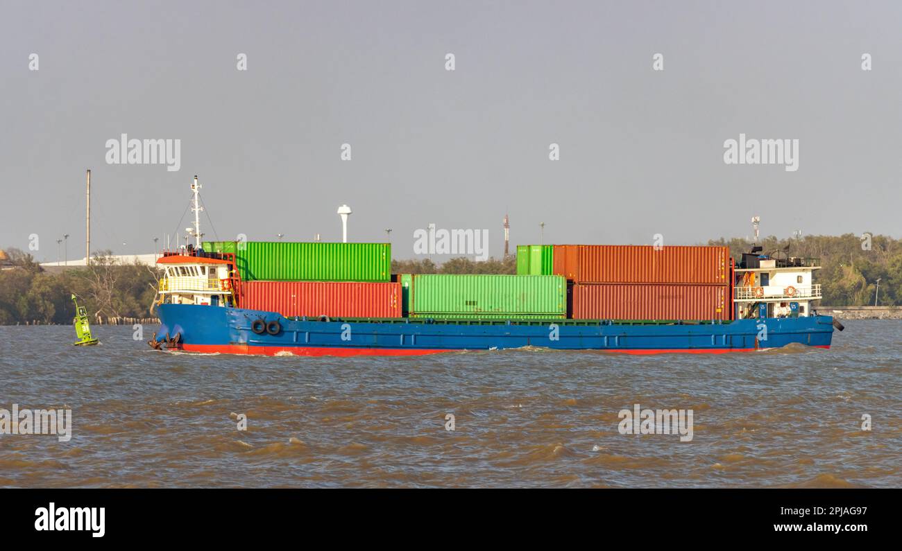 Das mit Containern beladene Frachtschiff fährt entlang der Küste Stockfoto