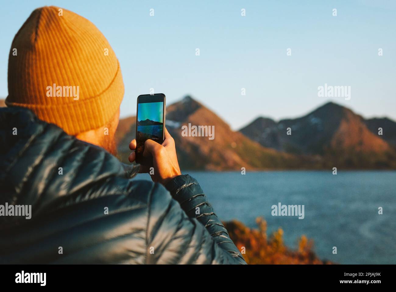 Mann mit Smartphone macht Foto in Norwegen Reise Lifestyle Abenteuer Urlaub Outdoor Blogger Beeinflusser Lifestyle moderne Online-Technologie Stockfoto