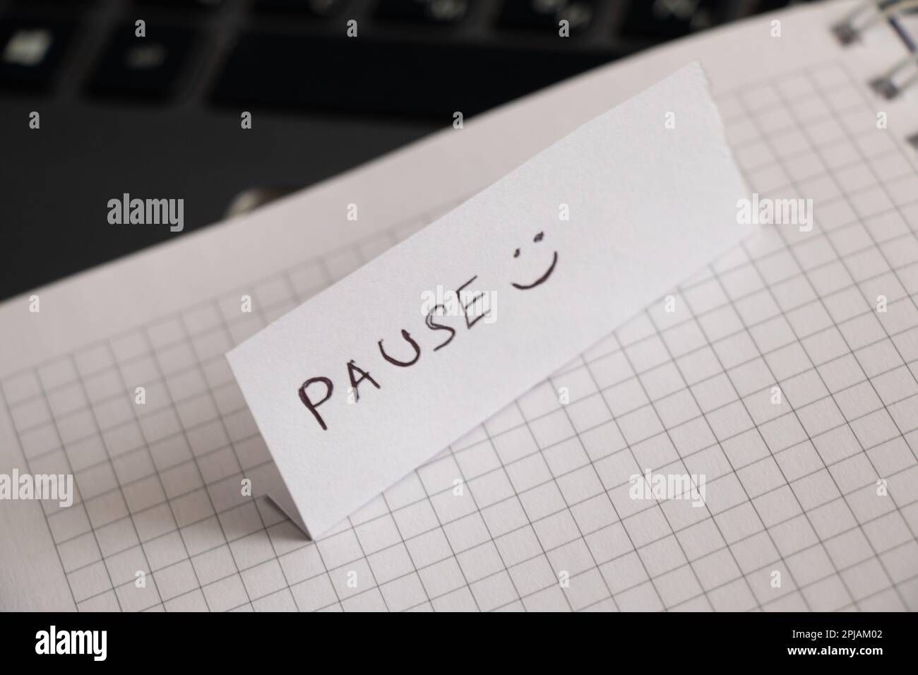 Pause und Smiley, handgeschrieben auf ein Stück Papier und dann gegangen Stockfoto