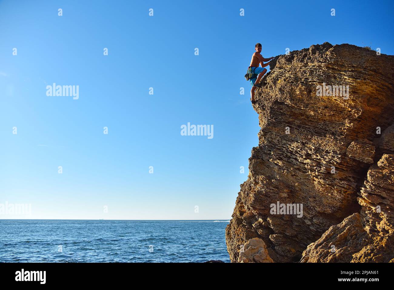 Junger Felskletterer auf dem gelben Berg. Stockfoto