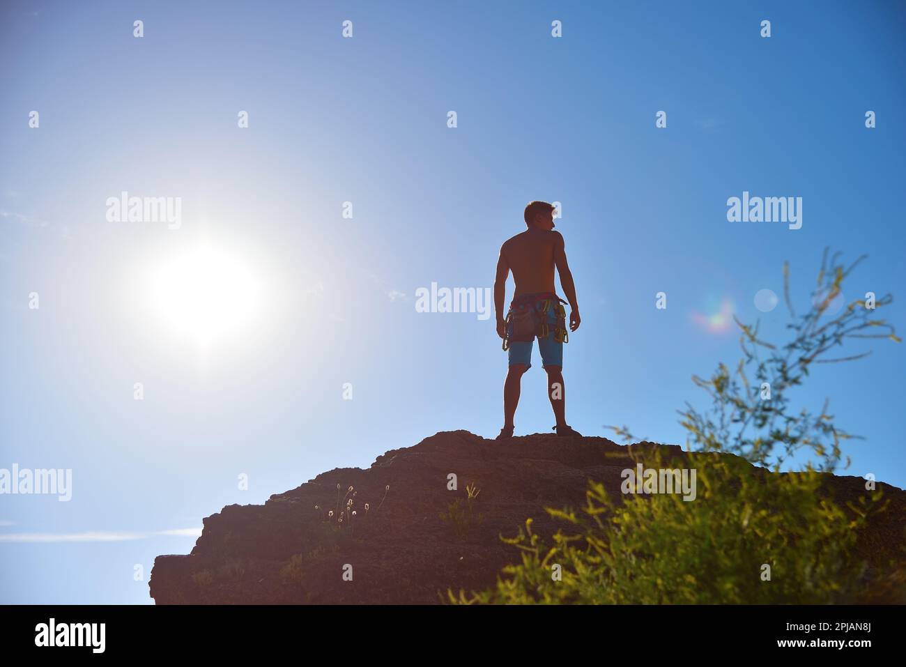 Extremer Kletterer auf Einem Felsen und Sonne im Himmel Stockfoto