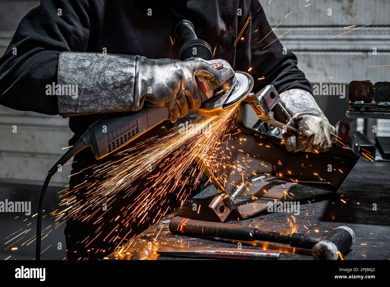Blick auf einen Arbeiter, der ein Stück Metall schleift, Frankreich Stockfoto
