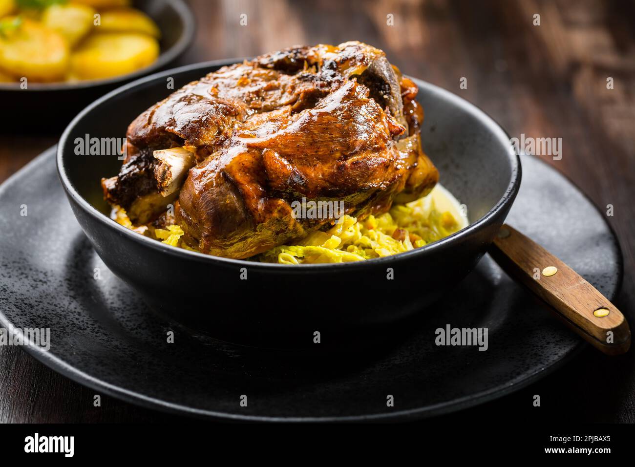 Röster Schweinshaxe mit Wirsing und gebackene Kartoffeln - traditionelle Gerichte der deutschen Küche, Eisbein, Schweinehaxe Stockfoto