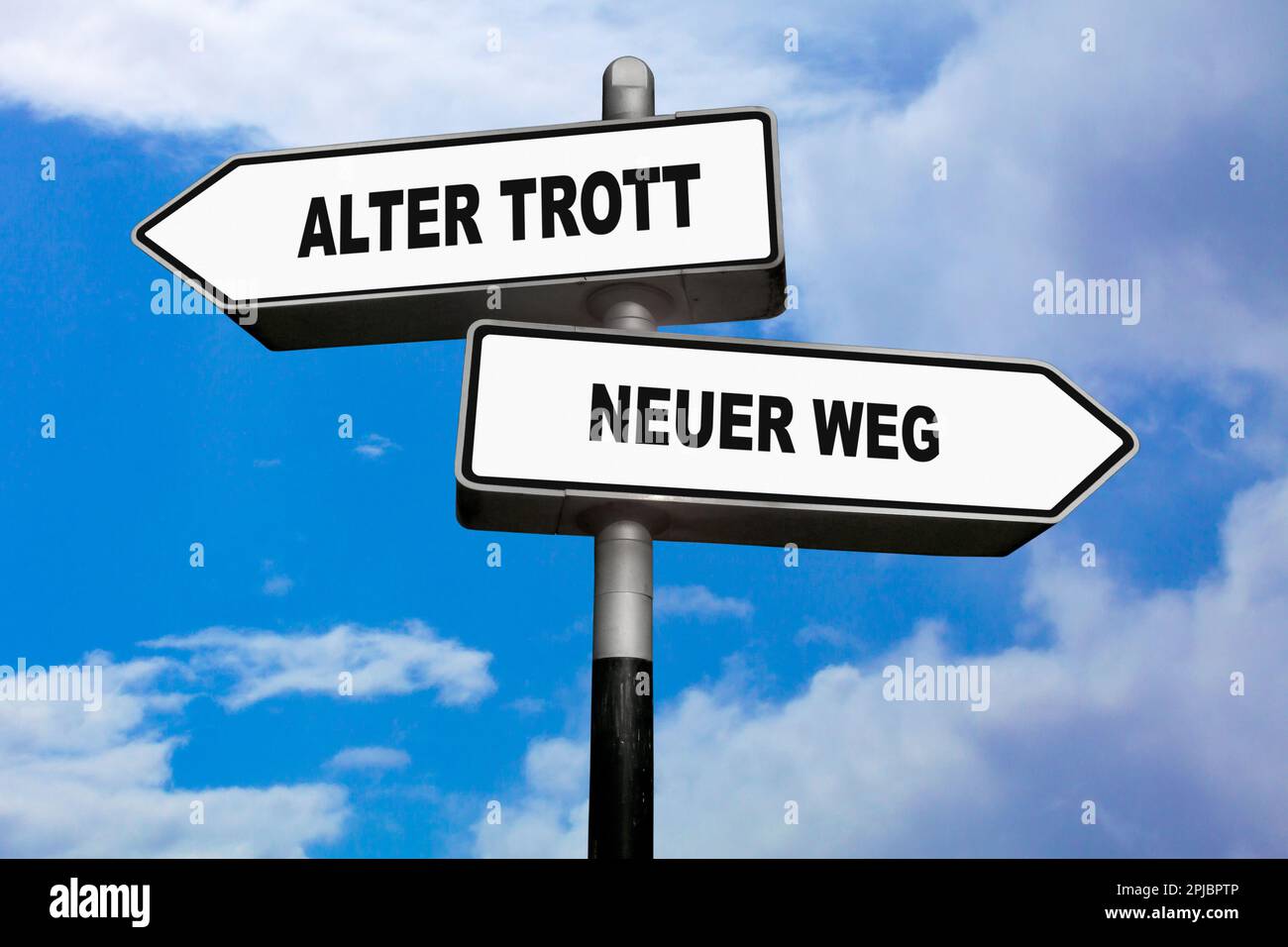 Zwei Wegweiser, eines nach links 'Alter Trott' (Deutsch: Alte Routine) und das andere nach rechts 'Neuer Weg' (Deutsch: Neue Richtung). Stockfoto