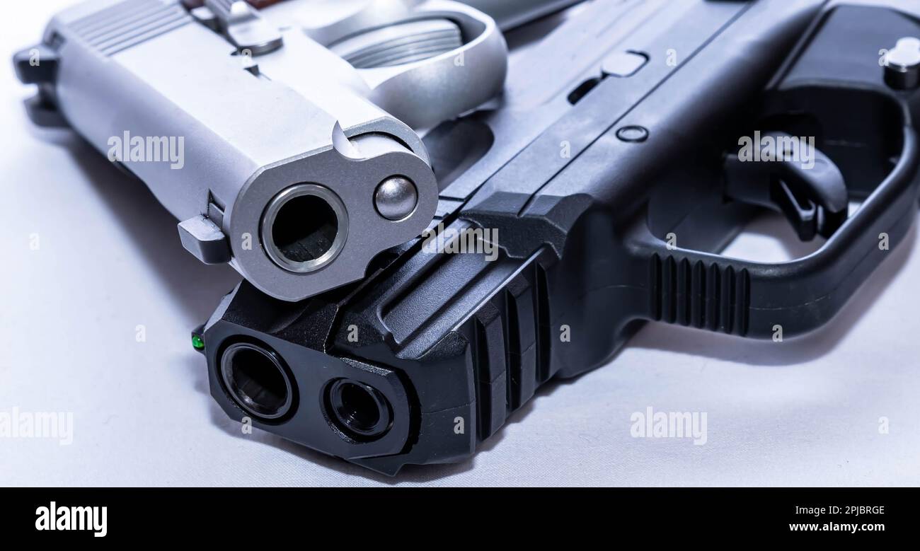 Zwei Pistolen, eine aus schwarzem und die andere aus rostfreiem Stahl, beide mit einem kaliber 380 acp auf weißem Hintergrund Stockfoto