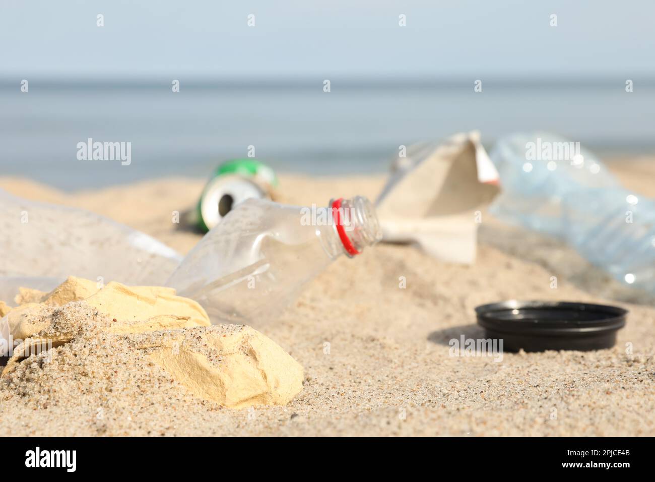 Müll verstreut am Strand in der Nähe des Meeres, dicht gemacht. Recycling-Problem Stockfoto