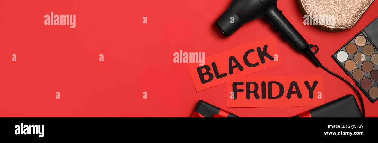 Kosmetikartikel, Tasche, Haarfön, Geschenkschachteln und „Black Friday“ auf rotem Hintergrund, flach liegend mit Platz für Text. Bannerdesign Stockfoto