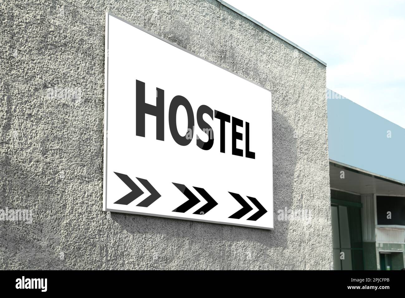 HOSTEL-Schild mit Pfeilen an der Gebäudefassade im Freien Stockfoto