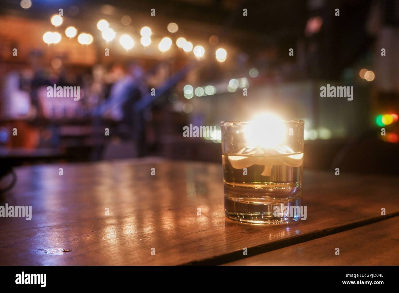 Bokeh-Hintergrund der Nachtbar mit einer Kerze auf dem Rahmen Stockfoto