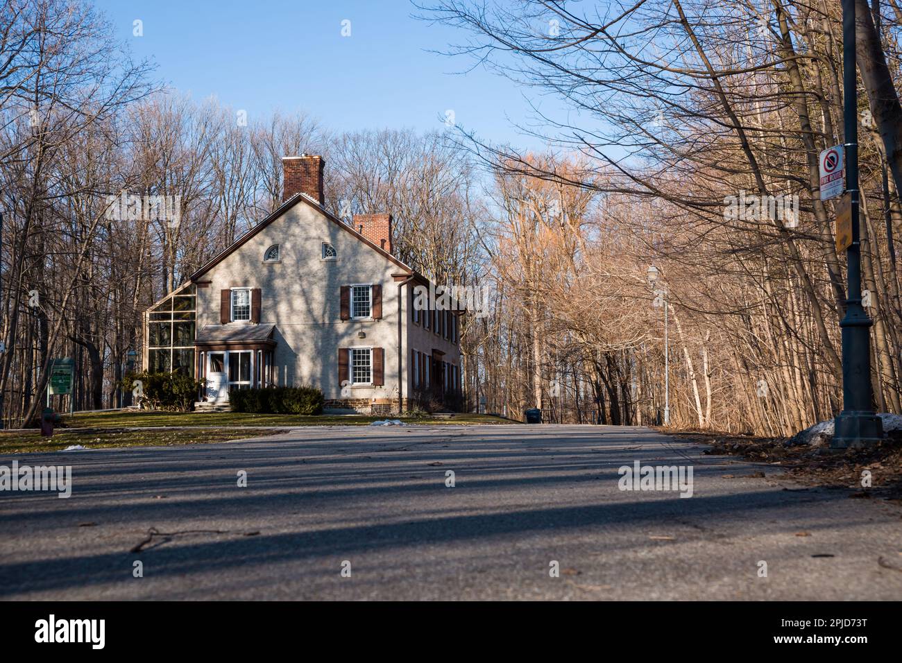 Fenster mit Holzläden und Blumen vor einer Steinmauer. Architekturdetails Stockfoto
